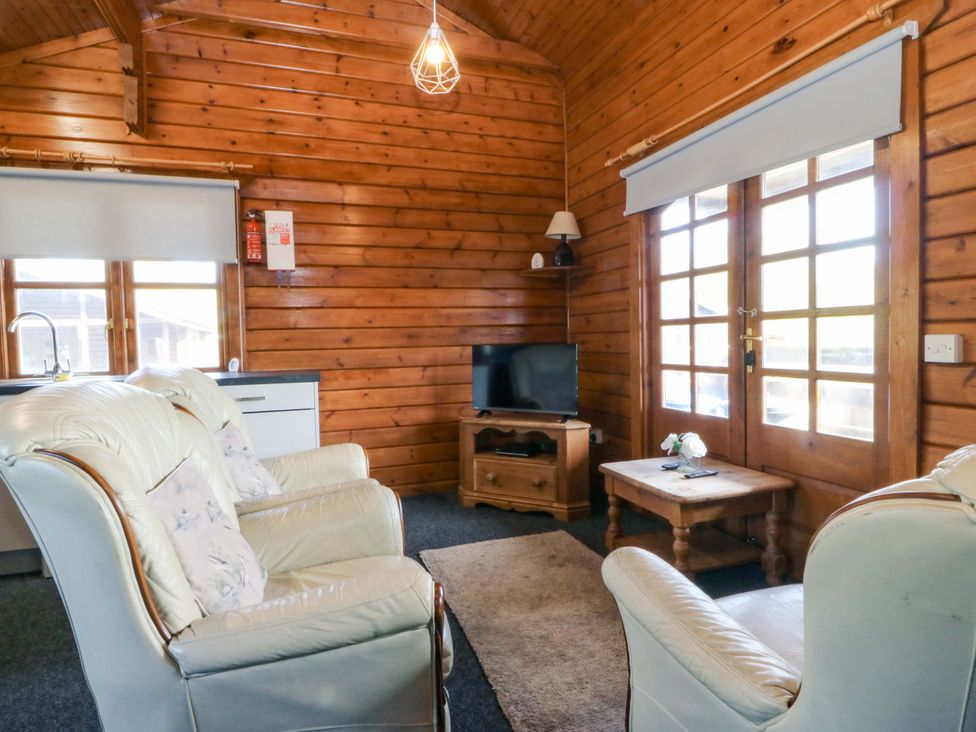 A living room with a television and seating area at Lodge 5 - Bron Eifion Criccieth