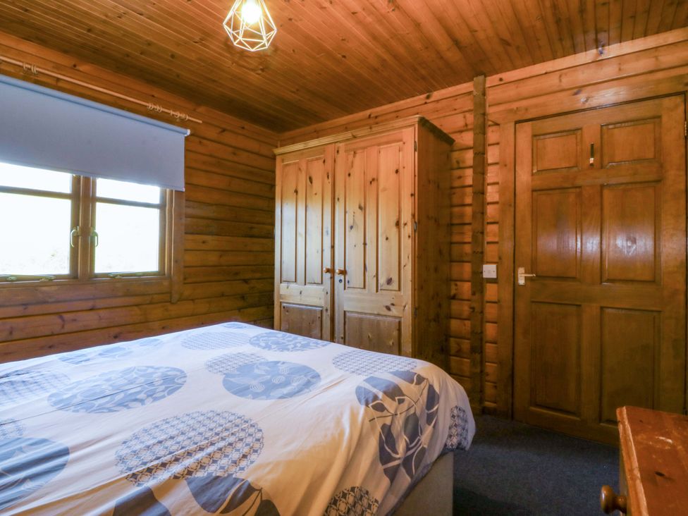 A bedroom with a bed and wardrobe at Lodge 5 - Bron Eifion, Criccieth