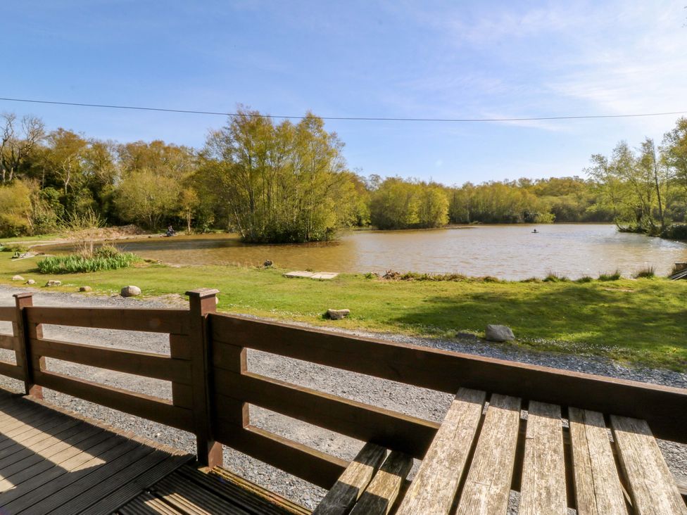 A view of a lake surrounded by trees and grass at Lodge 5 - Bron Eifion Criccieth