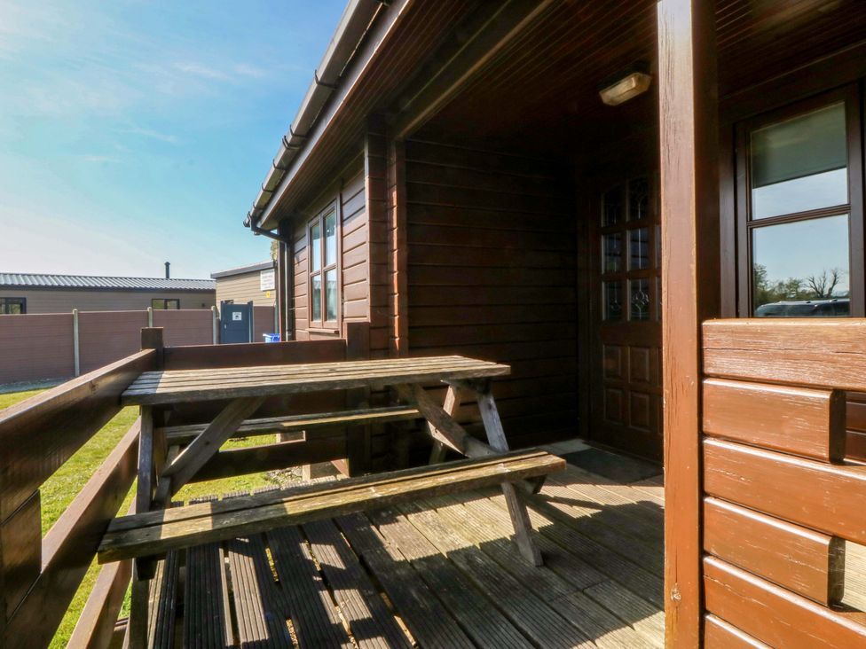 An outdoor area with a picnic table and entrance at Lodge 5 - Bron Eifion, Criccieth