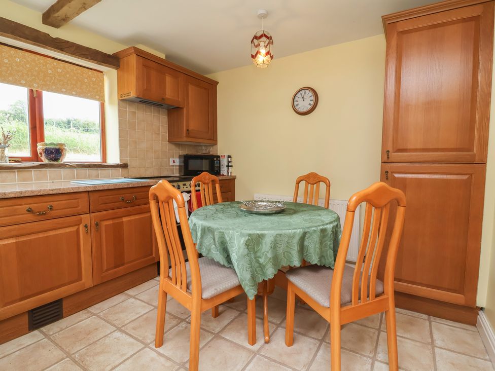A kitchen with wooden cabinets and a dining table at The Retreat near Wellington