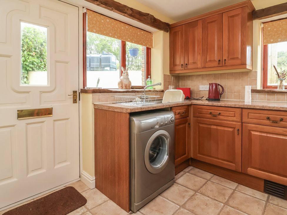 A kitchen with a washing machine and front door at The Retreat near Wellington