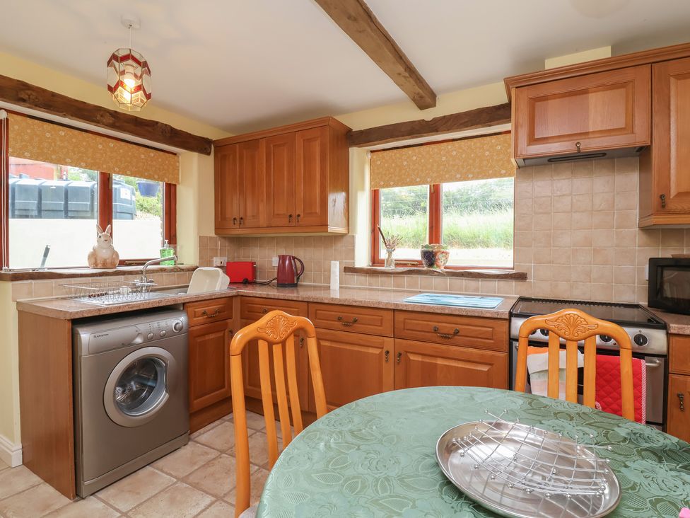 A kitchen with wooden cabinets and a washing machine at The Retreat near Wellington