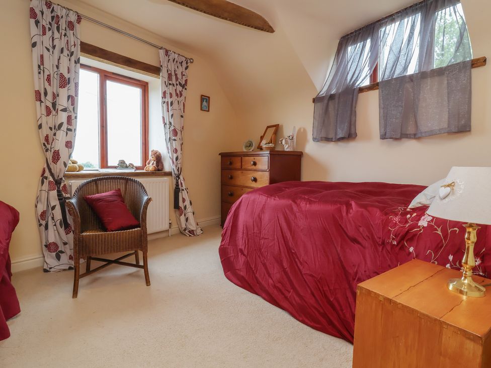 A bedroom with a bed, chair and window at The Retreat near Wellington