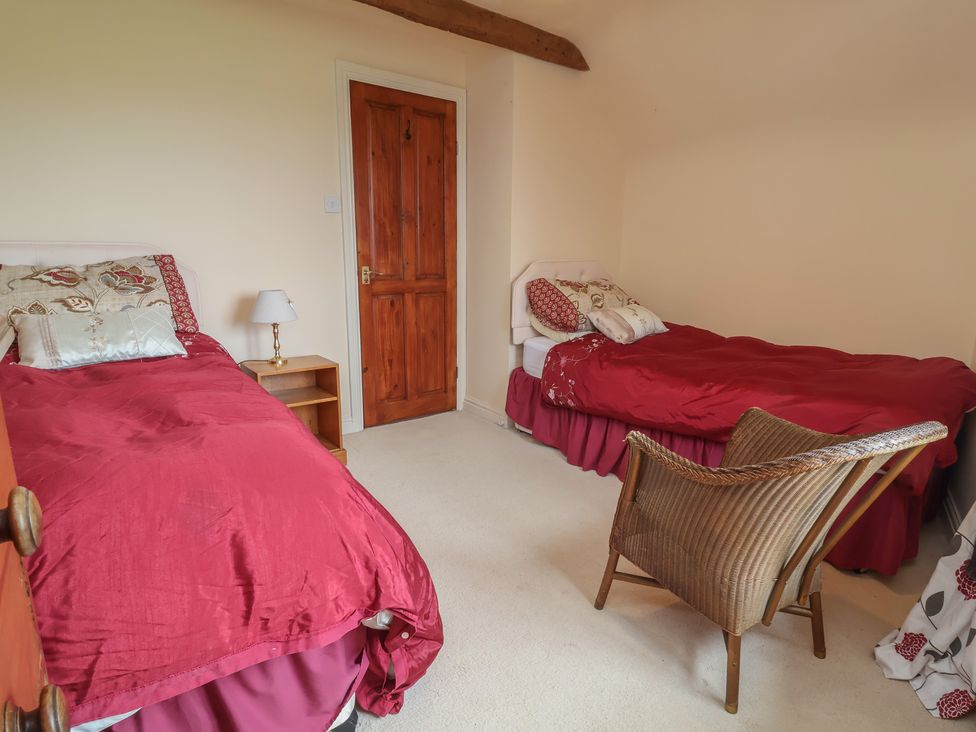 A bedroom with two beds and a chair at The Retreat near Wellington