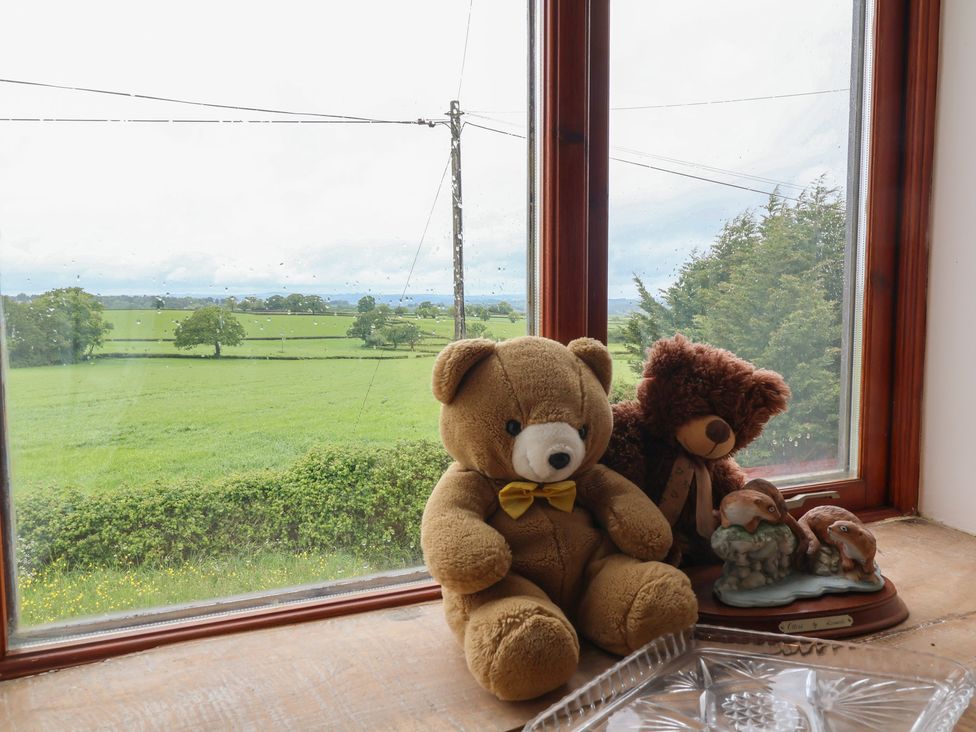 A window with teddy bears and a figurine overlooking fields at The Retreat near Wellington