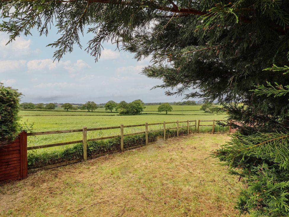 A garden view with a fence and trees at The Retreat near Wellington