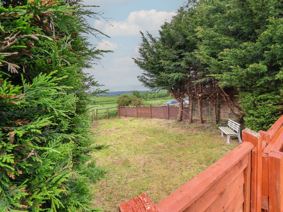 A garden with a bench and trees at The Retreat near Wellington