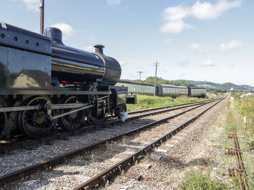A steam locomotive near railway tracks with train carriages at The Retreat near Wellington