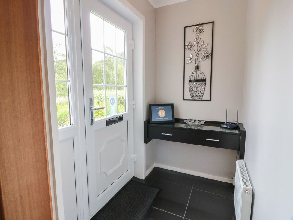 A hallway with a front door and console table at Cliff View in Perth