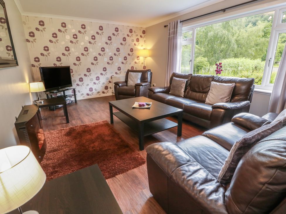 A living room with sofas, a coffee table, and a television at Cliff View in Perth