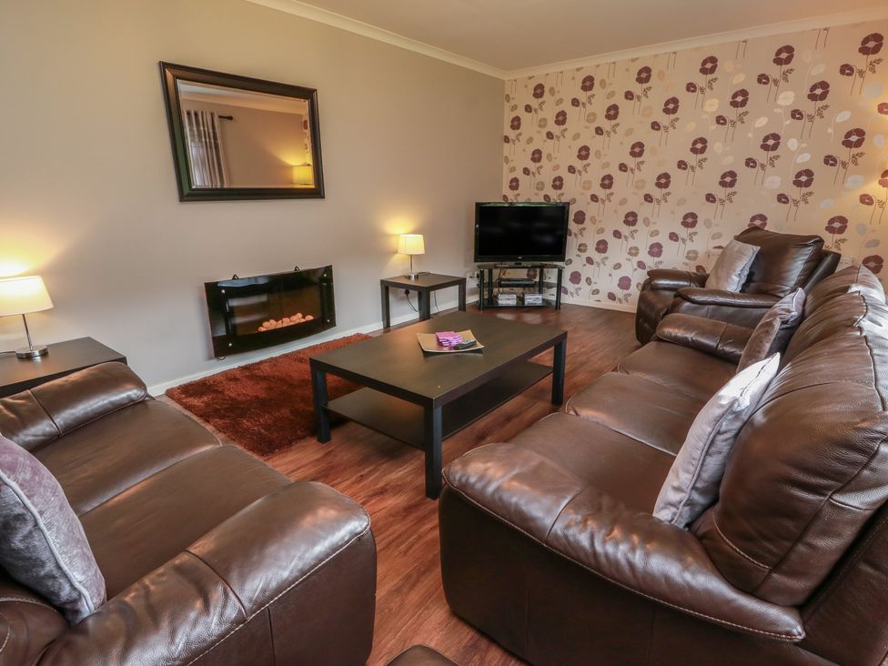 A living room with a coffee table and television at Cliff View in Perth