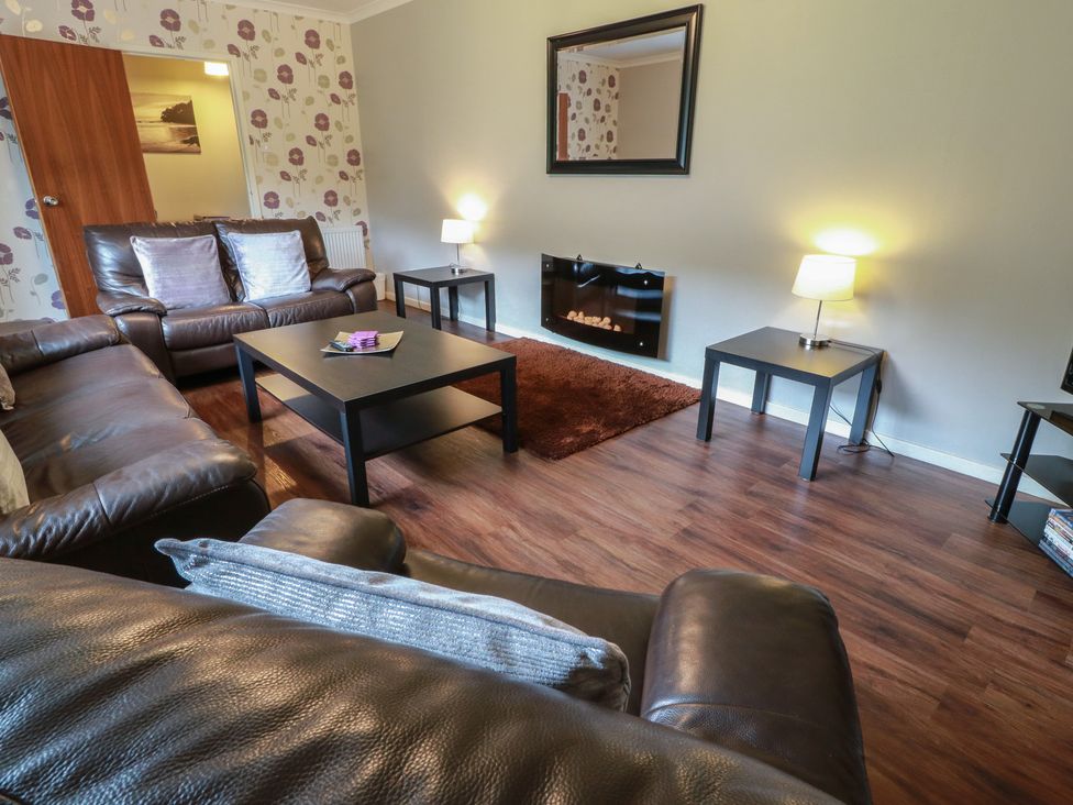 A living room with a coffee table and lamp at Cliff View in Perth