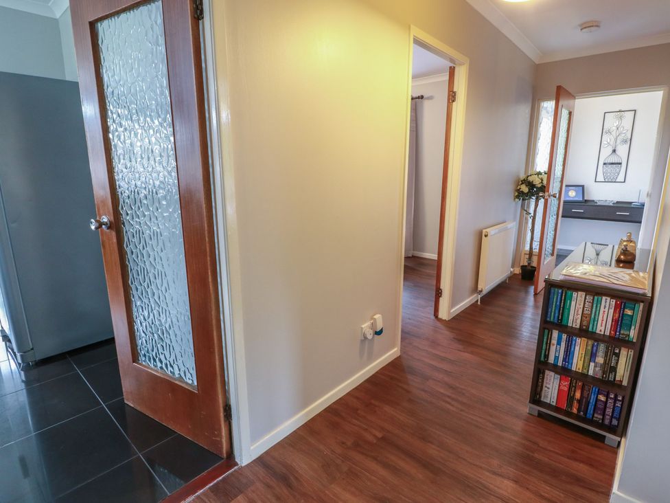 A hallway with a bookshelf and doors at Cliff View in Perth