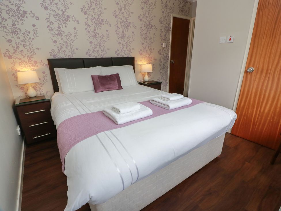 A bedroom with a bed, nightstands and lamps at Cliff View in Perth