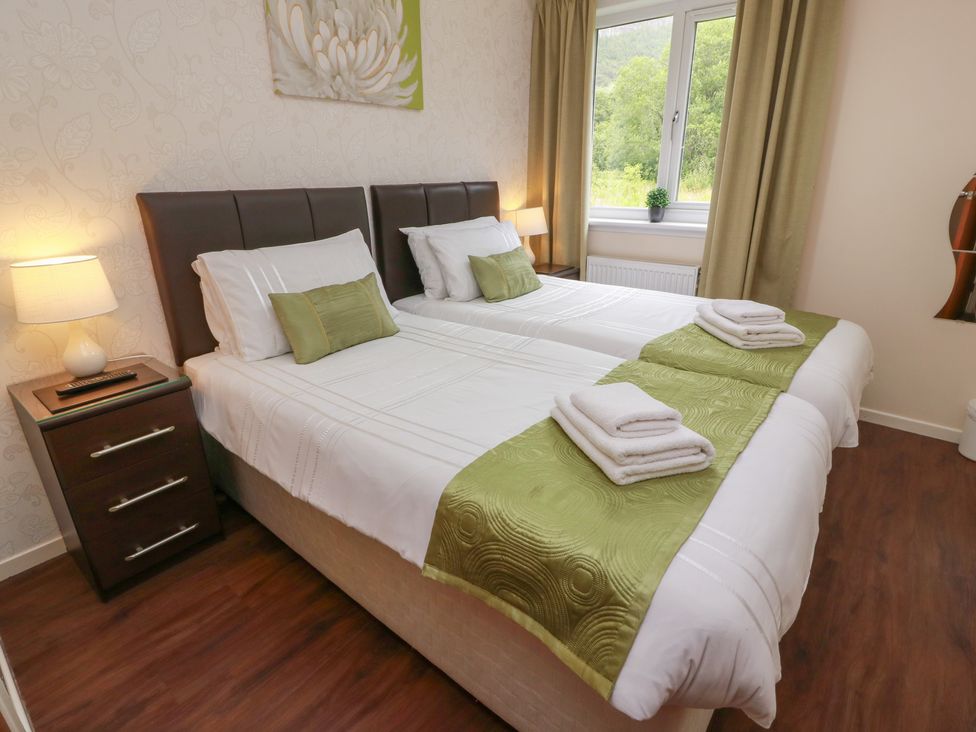 A bedroom with two single beds and a lamp at Cliff View in Perth