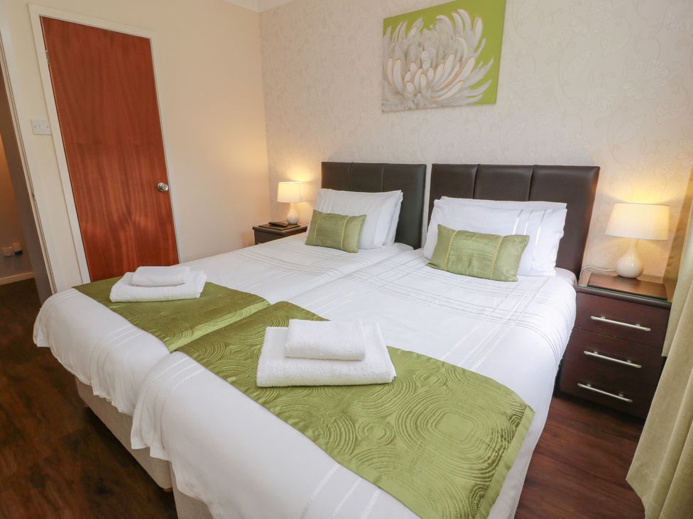 A bedroom with twin beds and a bedside table at Cliff View in Perth