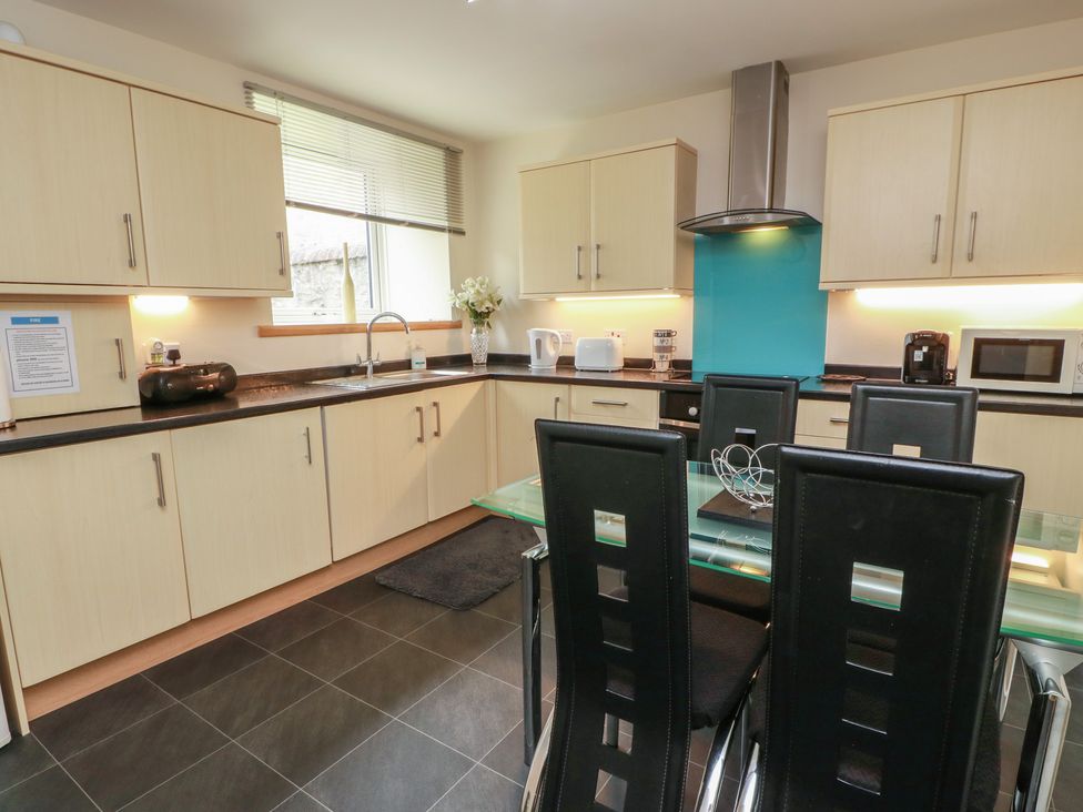 A kitchen with cabinets, sink, and table at 1 St. Catherines Cottages in Perth