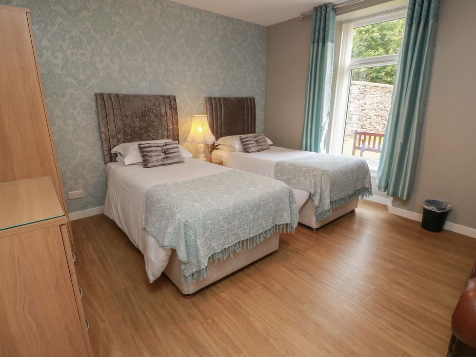 A bedroom with two beds and a window at 1 St. Catherines Cottages in Perth