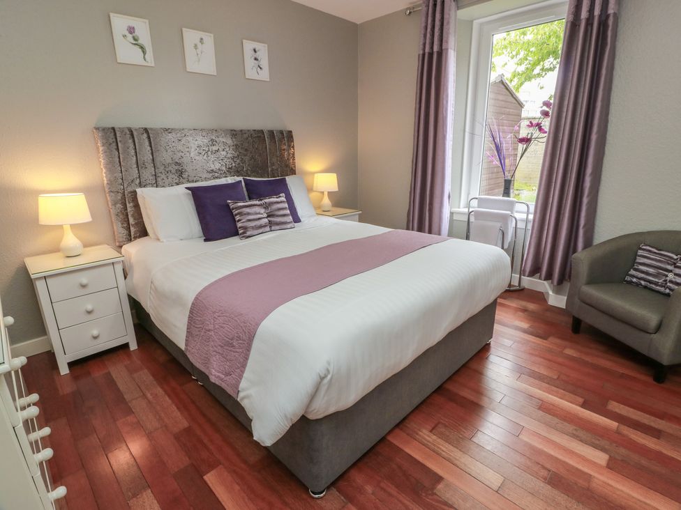 A bedroom with a bed and bedside table at 1 St. Catherines Cottages in Perth