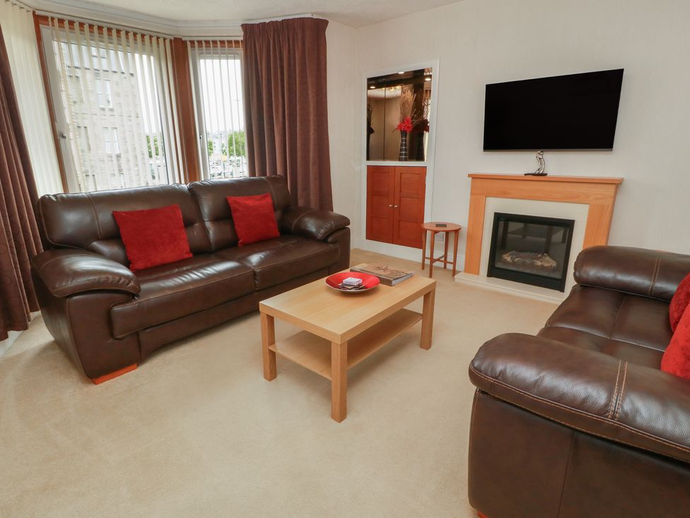 A living room with a sofa and coffee table at 2 St. Catherines Cottages in Perth