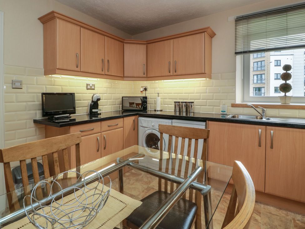 A kitchen with appliances and a dining area at 2 St. Catherines Cottages Perth