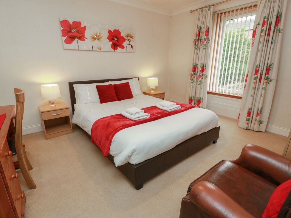 A bedroom with a large bed and bedside tables at 2 St. Catherines Cottages in Perth