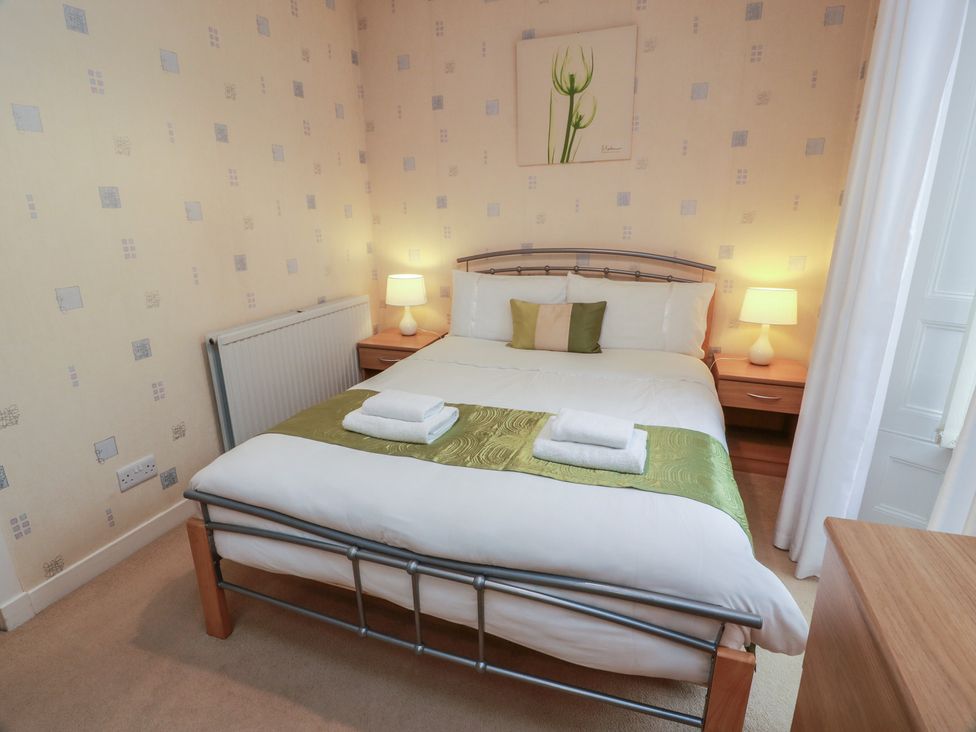 A bedroom with a double bed and bedside table at 2 St. Catherines Cottages in Perth