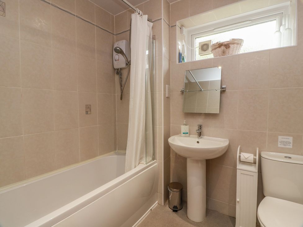 A bathroom with a bath tub, sink, and toilet at 2 St. Catherines Cottages in Perth