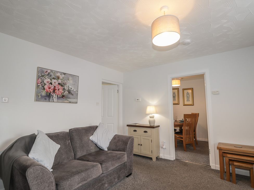 A living room with a sofa and a table at 3 Bruaich Cottages near Strathpeffer