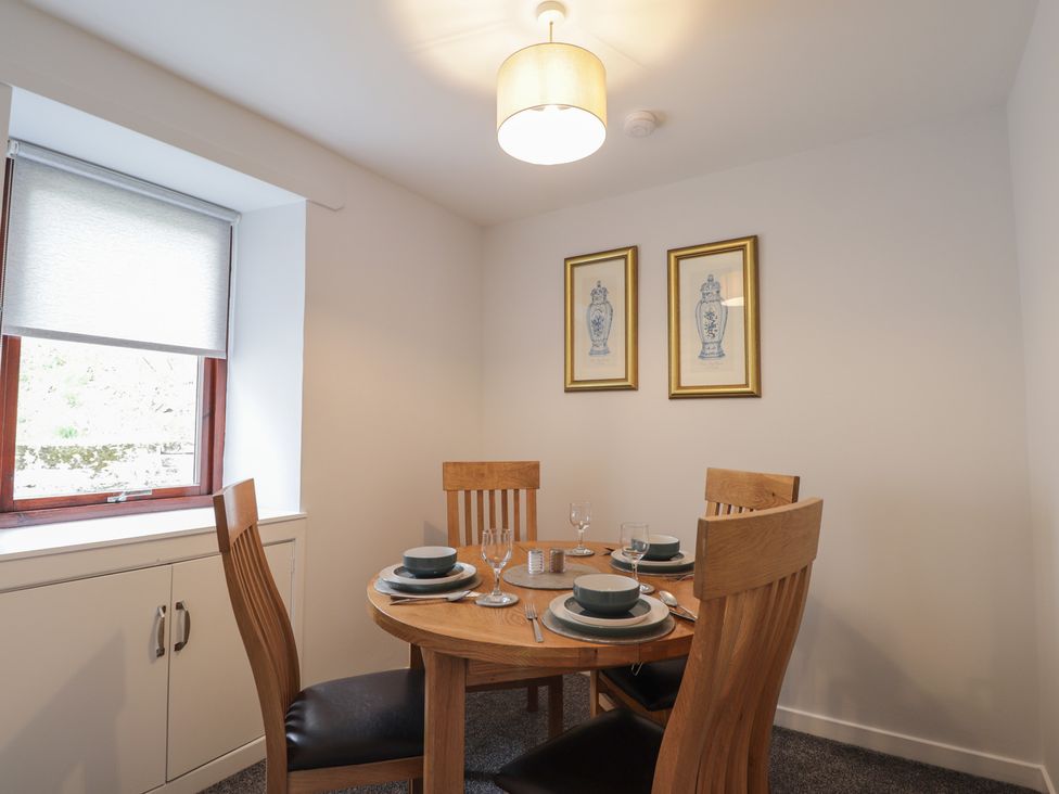 A dining room with a table set for four at 3 Bruaich Cottages near Strathpeffer