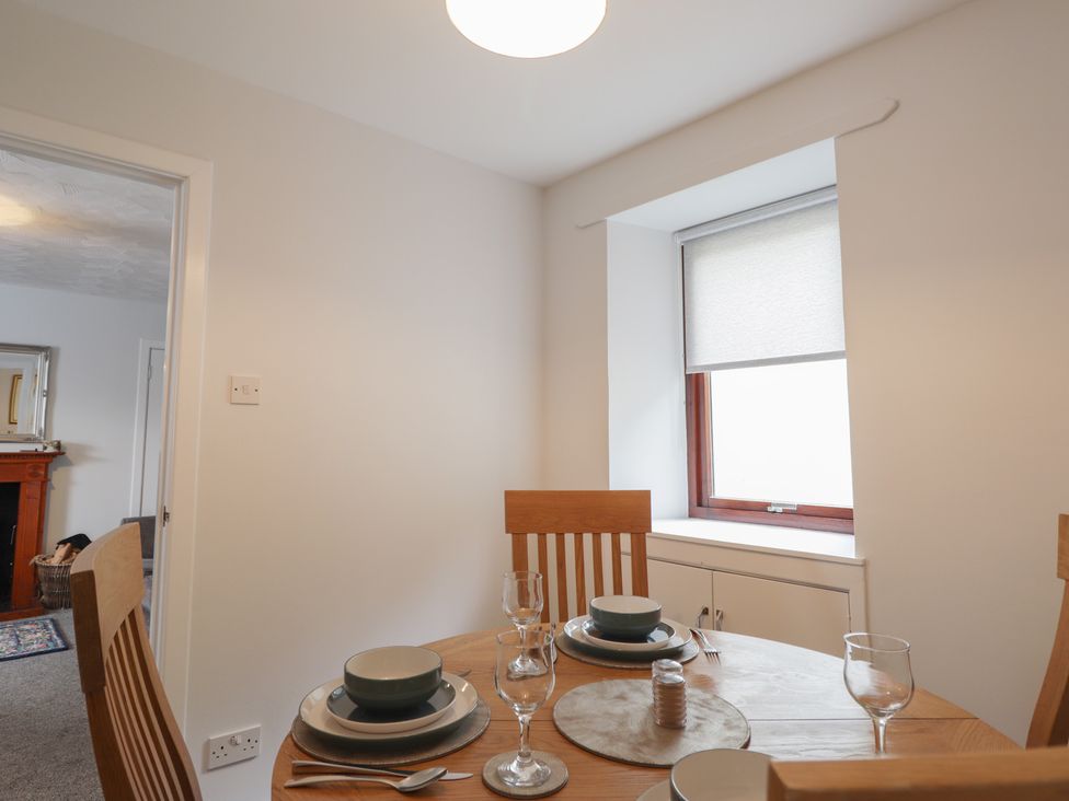 A dining room with a table set for meals at 3 Bruaich Cottages near Strathpeffer