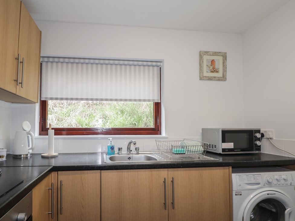 A kitchen with a sink and appliances at 3 Bruaich Cottages near Strathpeffer