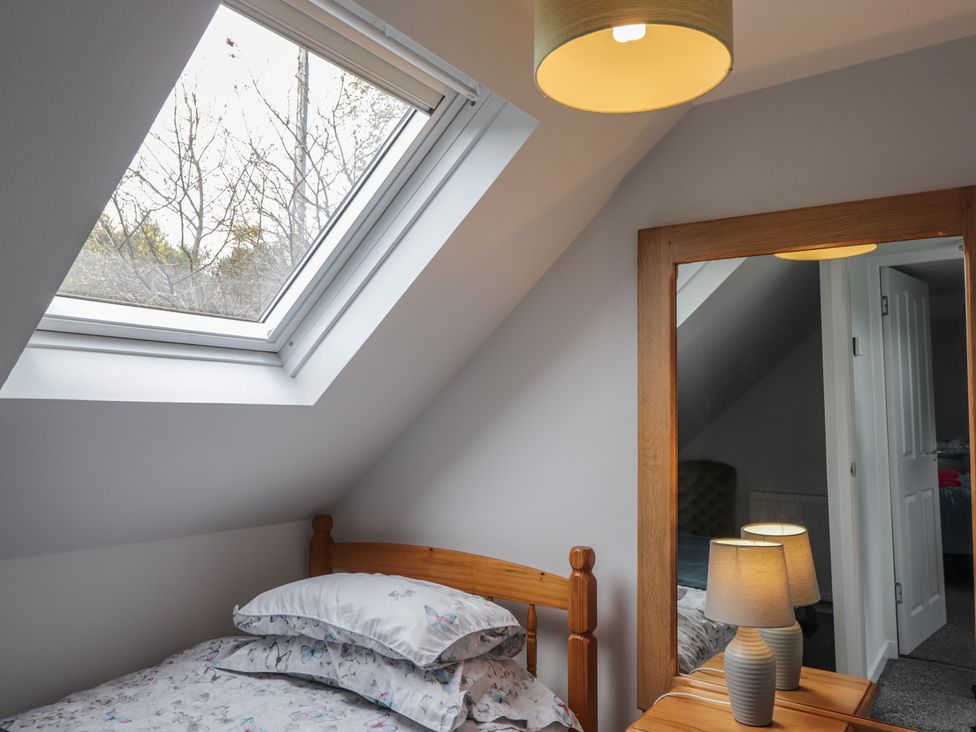 A bedroom with a window and a bed at 3 Bruaich Cottages near Strathpeffer