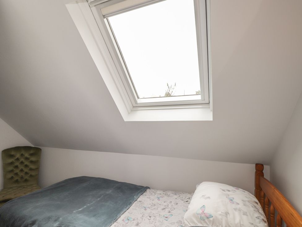 A bedroom with a bed and a skylight window at 3 Bruaich Cottages near Strathpeffer