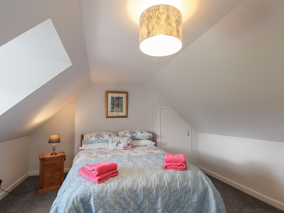 A bedroom with a bed and lamp at 3 Bruaich Cottages near Strathpeffer