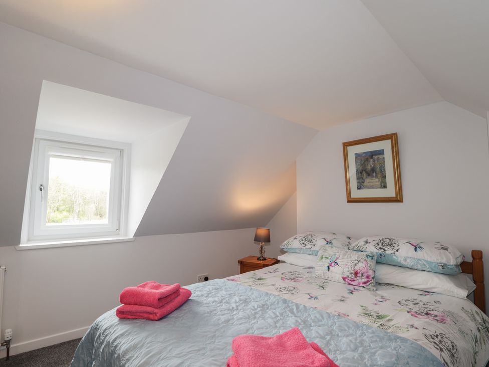 A bedroom with a bed and window at 3 Bruaich Cottages near Strathpeffer