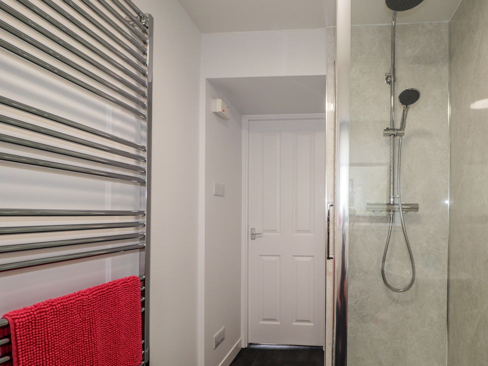 A bathroom with a shower and towel radiator at 3 Bruaich Cottages near Strathpeffer
