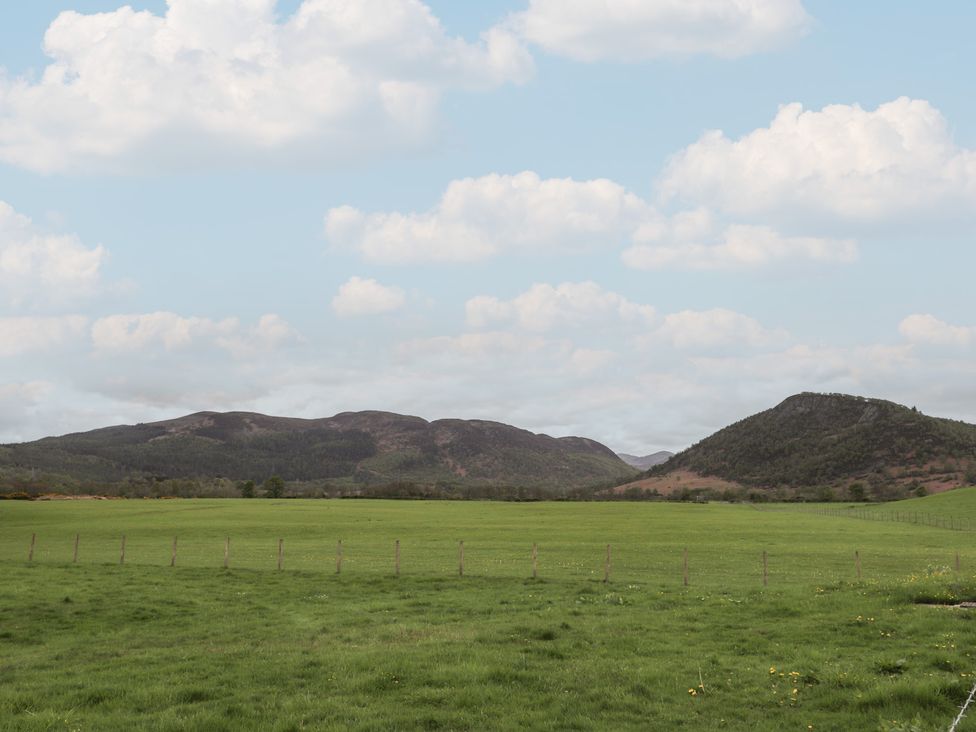 A landscape with mountains and grass fields at 3 Bruaich Cottages near Strathpeffer