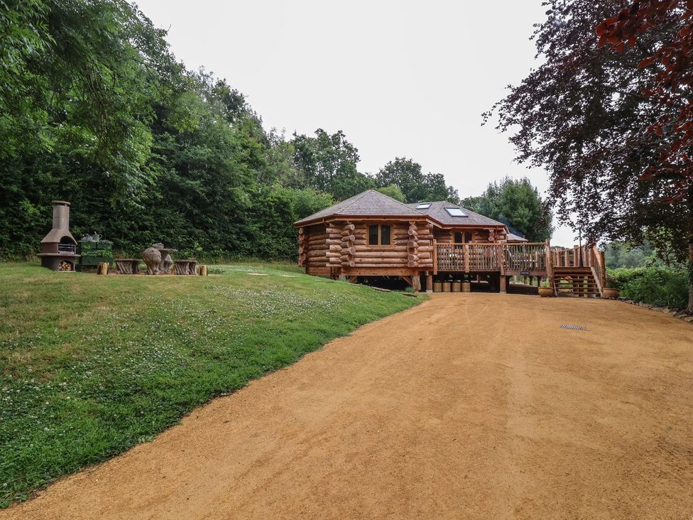 A log cabin with a deck and outdoor seating at Copper Suite in Chulmleigh