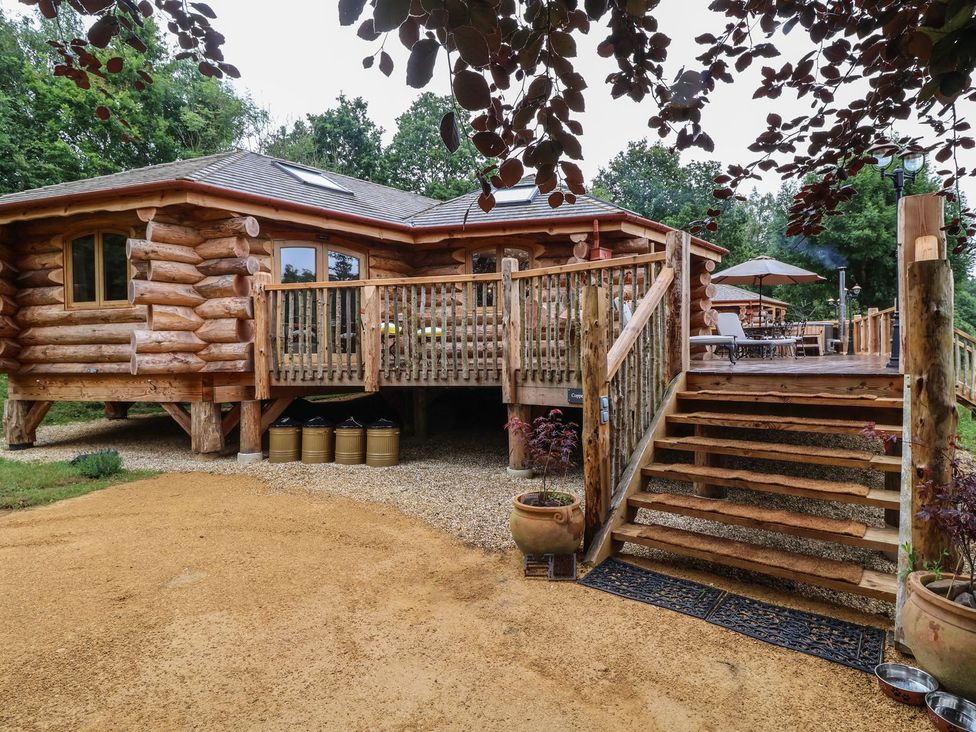 An outdoor area featuring a log cabin with a deck and steps at Copper Suite in Chulmleigh