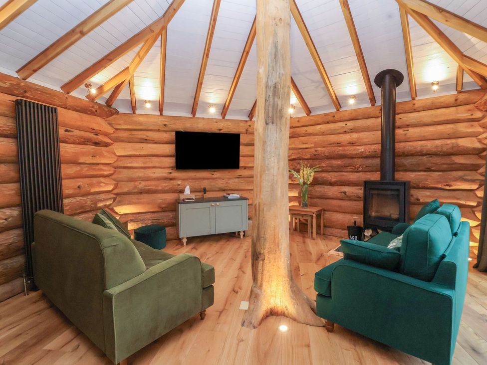 A living room with a log wall and sofas at Copper Suite in Chulmleigh