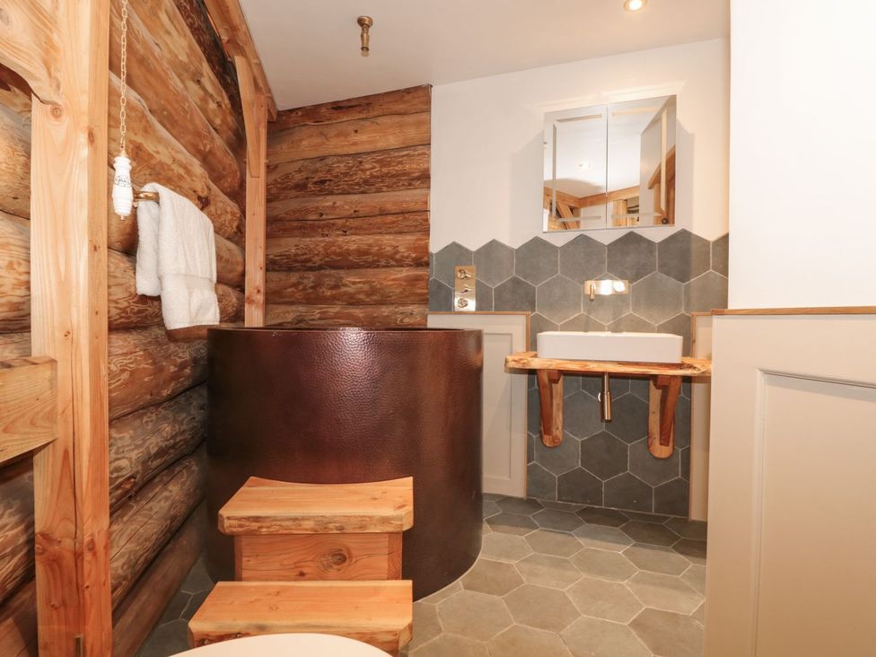 A bathroom with a bath tub and sink at Copper Suite in Chulmleigh