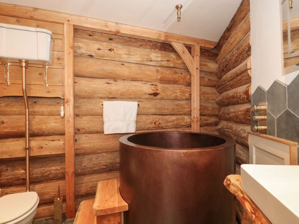 A bathroom with a bathtub, toilet, and sink at Copper Suite in Chulmleigh