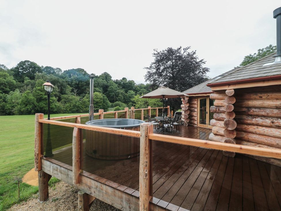 An outdoor area with a hot tub and seating at Copper Suite in Chulmleigh