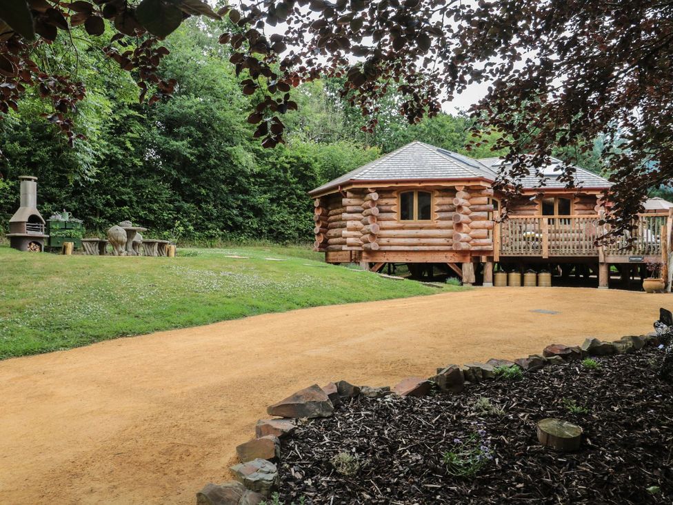 A log cabin with outdoor seating area at Copper Suite in Chulmleigh