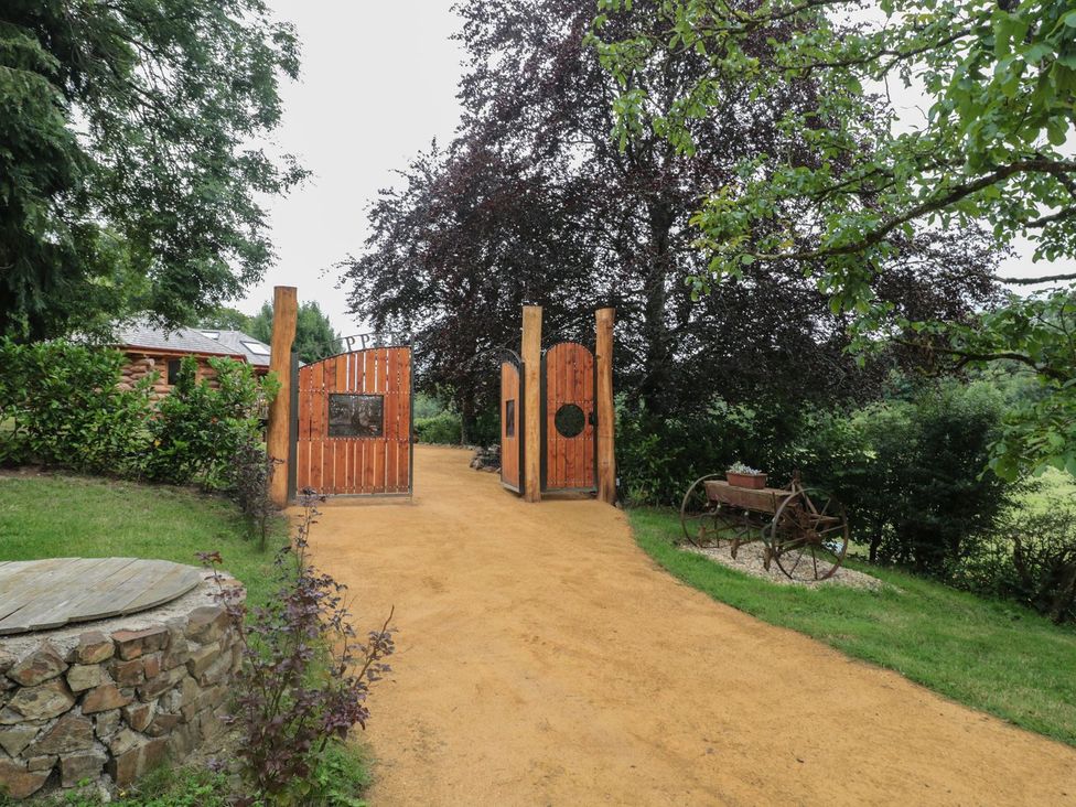 A garden entrance with wooden gates and a path at Copper Suite in Chulmleigh