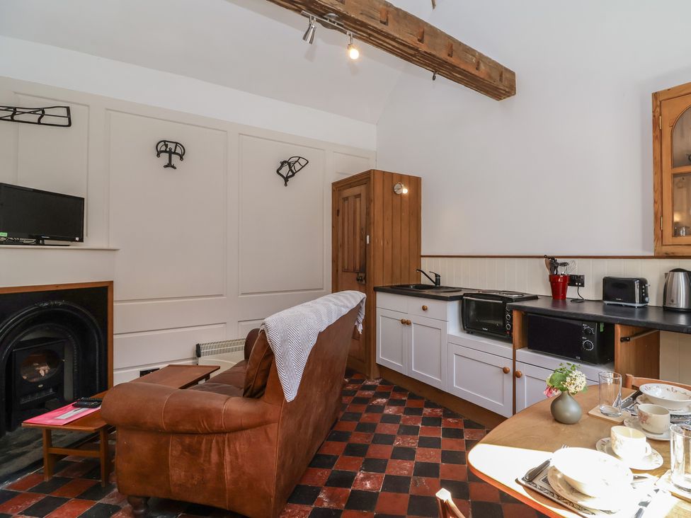 A kitchen with a sofa and television at Harness Rooms in Gloucester