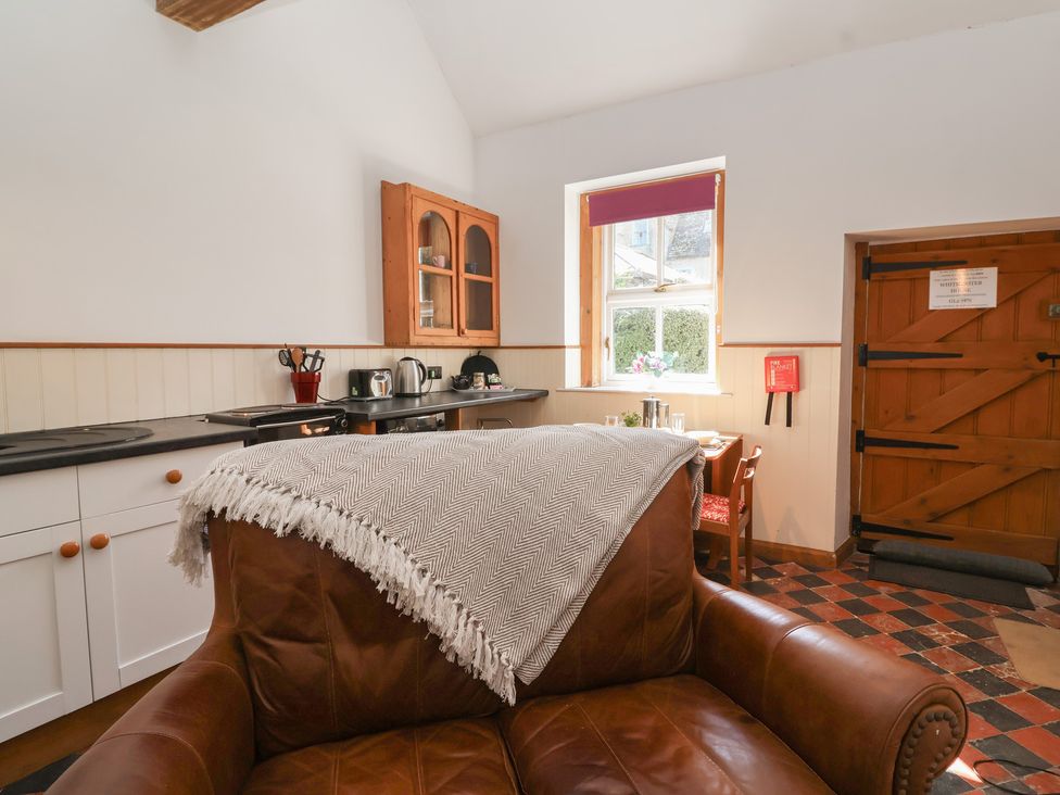 A kitchen with a sofa and a dining area at Harness Rooms Gloucester