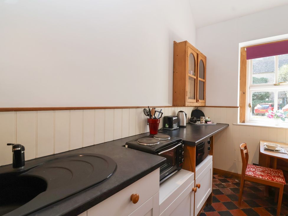 A kitchen with sink, stove, and dining table at Harness Rooms in Gloucester
